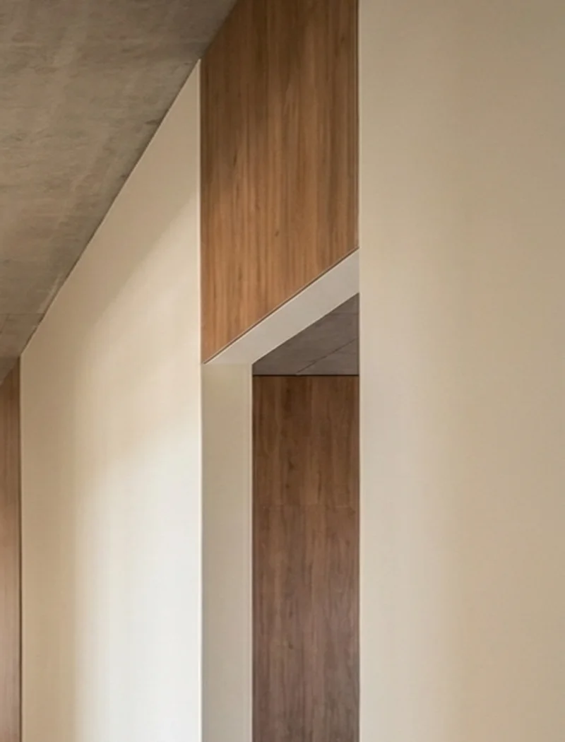 Junction of plaster, timber veneer and off-form concrete ceiling